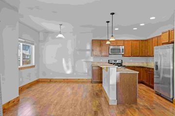 Bozeman apartment for rent - A kitchen with wooden cabinets and a white island.
