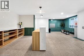 Brantford condo for rent - A room with a white ceiling and a wooden floor with a white column in the middle.