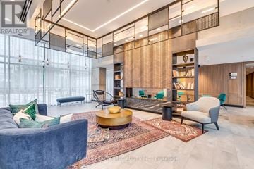 Toronto (Mimico) condo for rent - A modern living room with a dark blue sofa and a wooden coffee table.