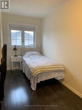 Mississauga (Hurontario) townhouse for rent - A bedroom with a bed, nightstand, and chair.