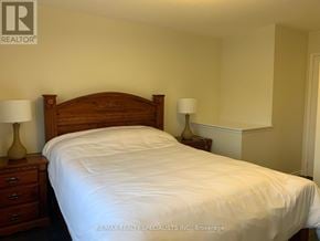 Mississauga (Hurontario) townhouse for rent - A bedroom with a bed, nightstands, and lamps.
