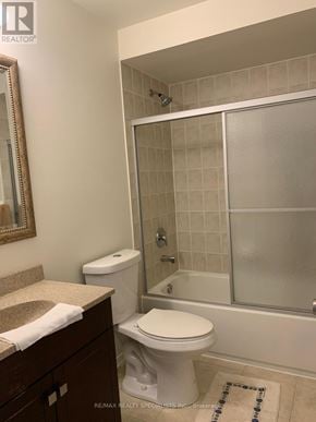 Mississauga (Hurontario) townhouse for rent - A white toilet sits in a bathroom next to a sink and a walk-in shower.
