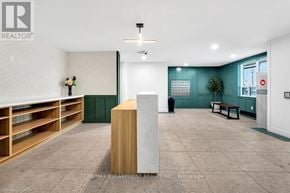 Brantford condo for rent - A room with a white ceiling and a wooden floor with a white column in the middle.