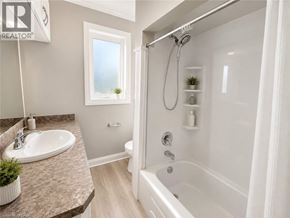 Ancaster apartment for rent - A bathroom with a white tub, sink, and shower.