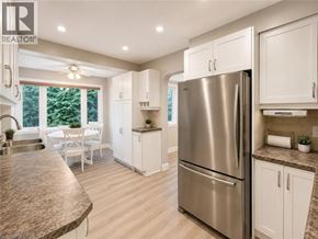 Ancaster apartment for rent - A modern kitchen with a stainless steel refrigerator and white cabinets.