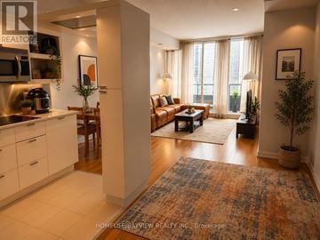 Toronto (Bay Street Corridor) condo for rent - A well-lit, modern kitchen and living room with a rug on the floor.