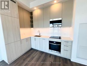 Vaughan (Vaughan Corporate Centre) condo for rent - A kitchen with wooden cabinets and a stainless steel oven.