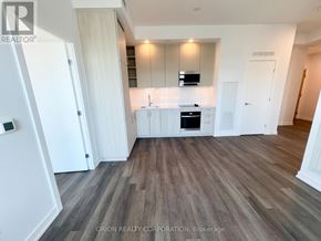 Vaughan (Vaughan Corporate Centre) condo for rent - A modern kitchen with white cabinets and a wooden floor.