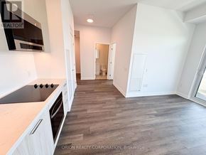 Vaughan (Vaughan Corporate Centre) condo for rent - A kitchen with white cabinets and a wooden floor.