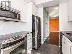 Toronto (Islington-City Centre West) condo for rent - A kitchen with a stove top oven and a refrigerator.