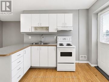 Hamilton (Eastmount) house for rent - A kitchen with white cabinets and a wooden counter top.