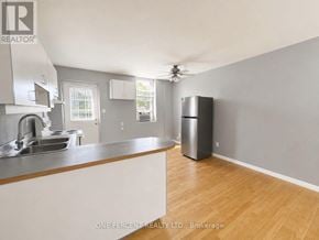 Hamilton (Eastmount) house for rent - A kitchen with a stainless steel sink and a wooden floor.