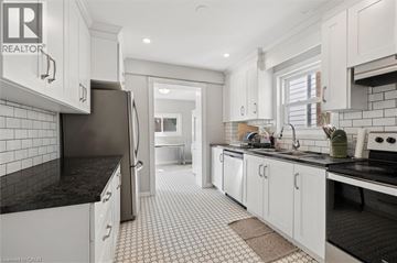 Kitchener apartment for rent - A modern kitchen with white cabinets and black countertops.