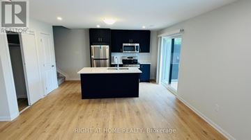 Ottawa townhouse for rent - A spacious kitchen with a black island and wooden floors.