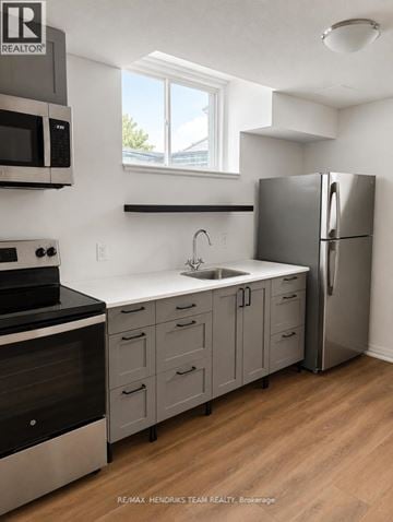 Thorold (Confederation Heights) townhouse for rent - A kitchen with a refrigerator, sink, and stove.