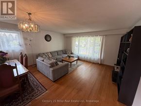 Brampton (Brampton East) apartment for rent - A living room with a grey couch and a wooden floor.