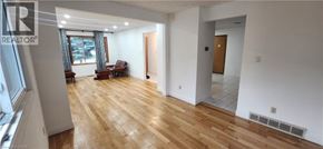 Kitchener apartment for rent - A large, empty room with wooden floors and white walls.