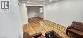 Kitchener apartment for rent - A living room with a brown leather couch and a glass coffee table.