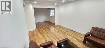 Kitchener apartment for rent - A living room with a brown leather couch and a glass coffee table.