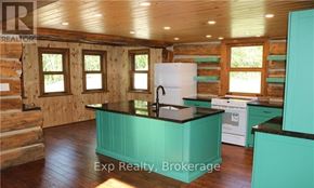 Prince Edward County (North Marysburg Ward) apartment for rent - A kitchen with a white fridge and black countertops.