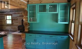 Prince Edward County (North Marysburg Ward) apartment for rent - A kitchen with teal cabinets and a wood stove.