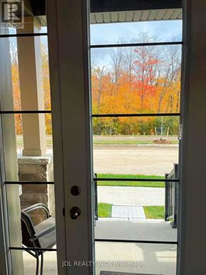Markham (Cornell) apartment for rent - A glass door with a handle and a glass window with a view of a tree with orange leaves.