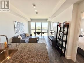 Milton (De Dempsey) condo for rent - A well-lit, modern living room with a kitchen area in the foreground.