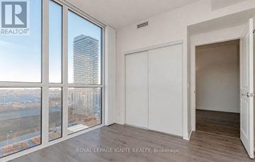 Toronto (Islington-City Centre West) condo for rent - A room with a view of a cityscape through large windows.
