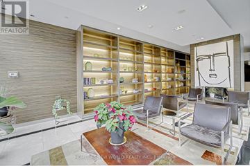 Toronto (Bay Street Corridor) condo for rent - A living room with a large bookshelf and a drawing of a face on the wall.