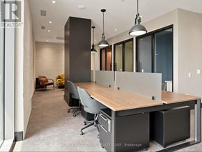 Milton (Om Old Milton) condo for rent - A modern office space with a long wooden table and grey chairs.