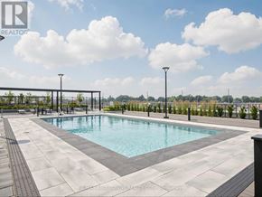 Milton (Om Old Milton) condo for rent - A large outdoor swimming pool surrounded by a concrete patio and metal fencing.