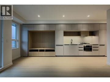 Port Moody apartment for rent - A spacious kitchen with white cabinets and a window.