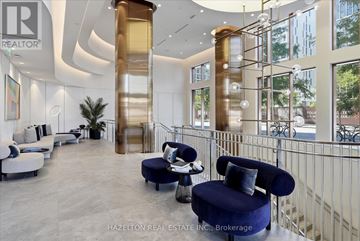 Toronto (Waterfront Communities) condo for rent - A modern living room with a blue chair and a staircase.