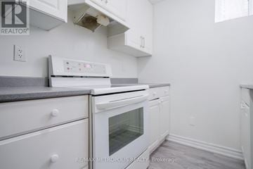 Pickering (Amberlea) apartment for rent - A white kitchen with a stove top oven and a microwave.