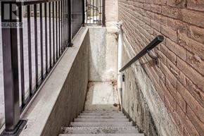 Pickering (Amberlea) apartment for rent - A staircase with a metal railing and a brick wall on one side.