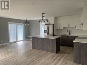 Azilda apartment for rent - A modern kitchen with a large island and a refrigerator.