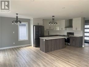 Azilda apartment for rent - A modern kitchen with wooden floors and a central island.