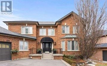 Vaughan (Islington Woods) multi-family for rent - A large brick house with a black front door and a tree in front.