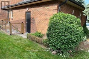 Vaughan (Islington Woods) multi-family for rent - A small brick house with a black door and a wooden fence.