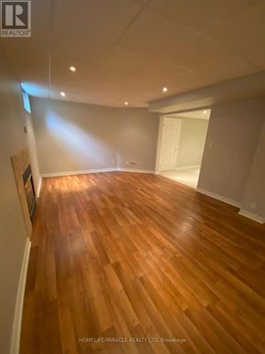 Vaughan (Islington Woods) multi-family for rent - A room with wooden flooring and white walls.