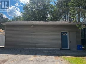 Whitchurch-Stouffville apartment for rent - A garage with a blue door is surrounded by trees.