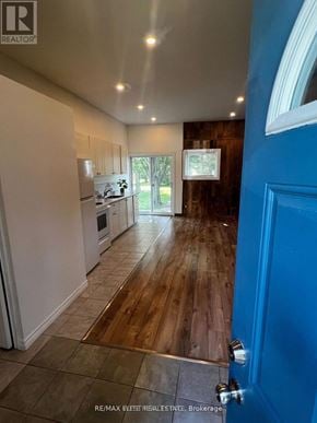 Whitchurch-Stouffville apartment for rent - A blue door is on the right side of a room with a kitchen in the background.
