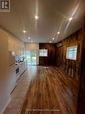 Whitchurch-Stouffville apartment for rent - A wooden floor in a room with a white fridge and a window.