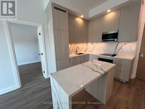 Vaughan (Vaughan Corporate Centre) condo for rent - A kitchen with a marble countertop and wooden cabinets.