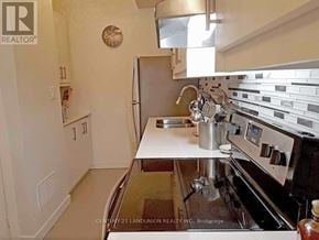 Toronto (Weston) townhouse for rent - A kitchen with a stove top oven and a refrigerator.
