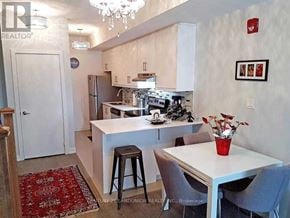 Toronto (Weston) townhouse for rent - A kitchen with a table and chairs in front of it.