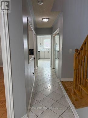 Mississauga (Meadowvale Village) apartment for rent - A hallway with a wooden staircase on the right.