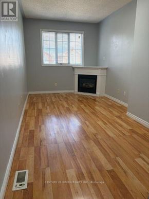 Mississauga (Meadowvale Village) apartment for rent - A room with a fireplace and wooden floors.