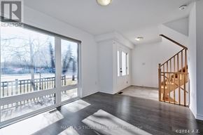 Oakville (Ga Glen Abbey) townhouse for rent - A room with a wooden staircase and a glass door leading to a balcony.