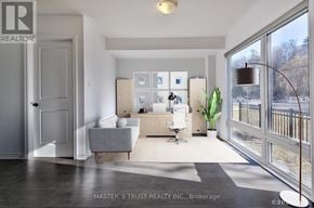 Oakville (Ga Glen Abbey) townhouse for rent - A realtor photo of a modern living room with a grey couch and a white chair.